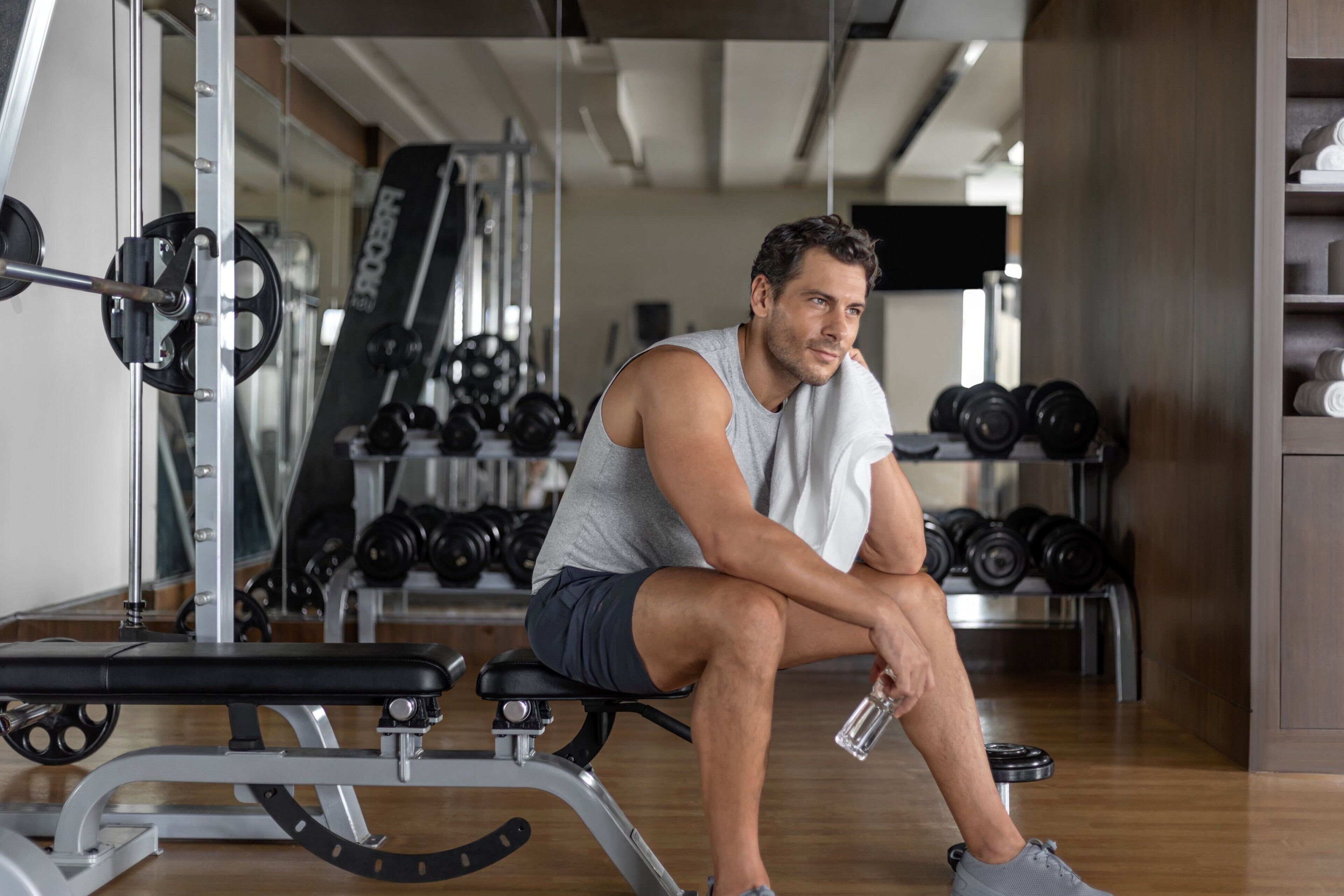 Une salle de sport équipée de matériel d’exercice, d’un banc et de poids.