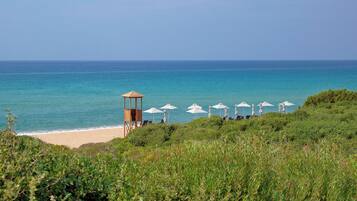 Aan het strand, ligstoelen aan het strand, parasols, strandlakens