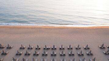 På stranden, solstolar, parasoller och strandhanddukar