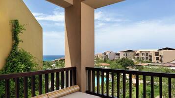 Ein Balkon mit Blick auf einen Pool und Gebäude im Hintergrund.