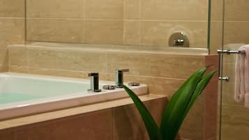 Un baño moderno con ducha de vidrio, bañera y tocador con espejo.