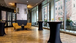 A modern interior with wooden flooring, black furniture, and large windows offering city views. - The Royal Sonesta Chicago River North (Chicago)