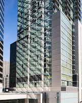 Un moderno edificio de gran altura con una cuadrícula de ventanas y fachadas de vidrio y concreto.