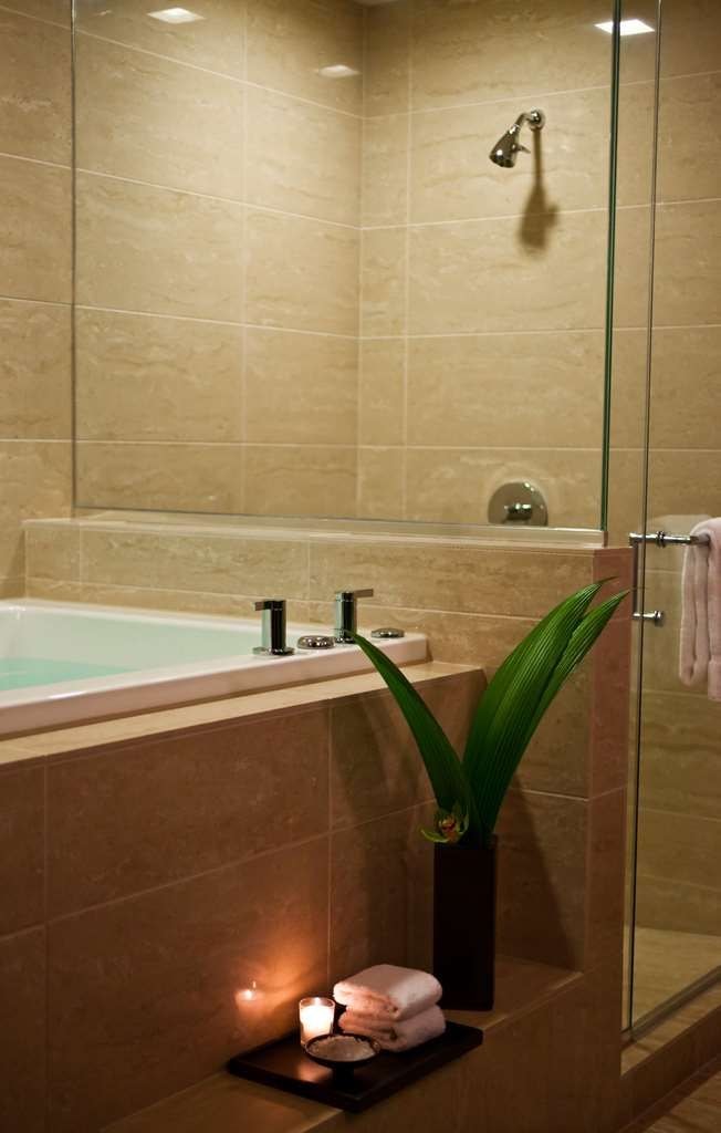 A modern bathroom with a glass-enclosed shower, a bathtub, and a vanity with a mirror.