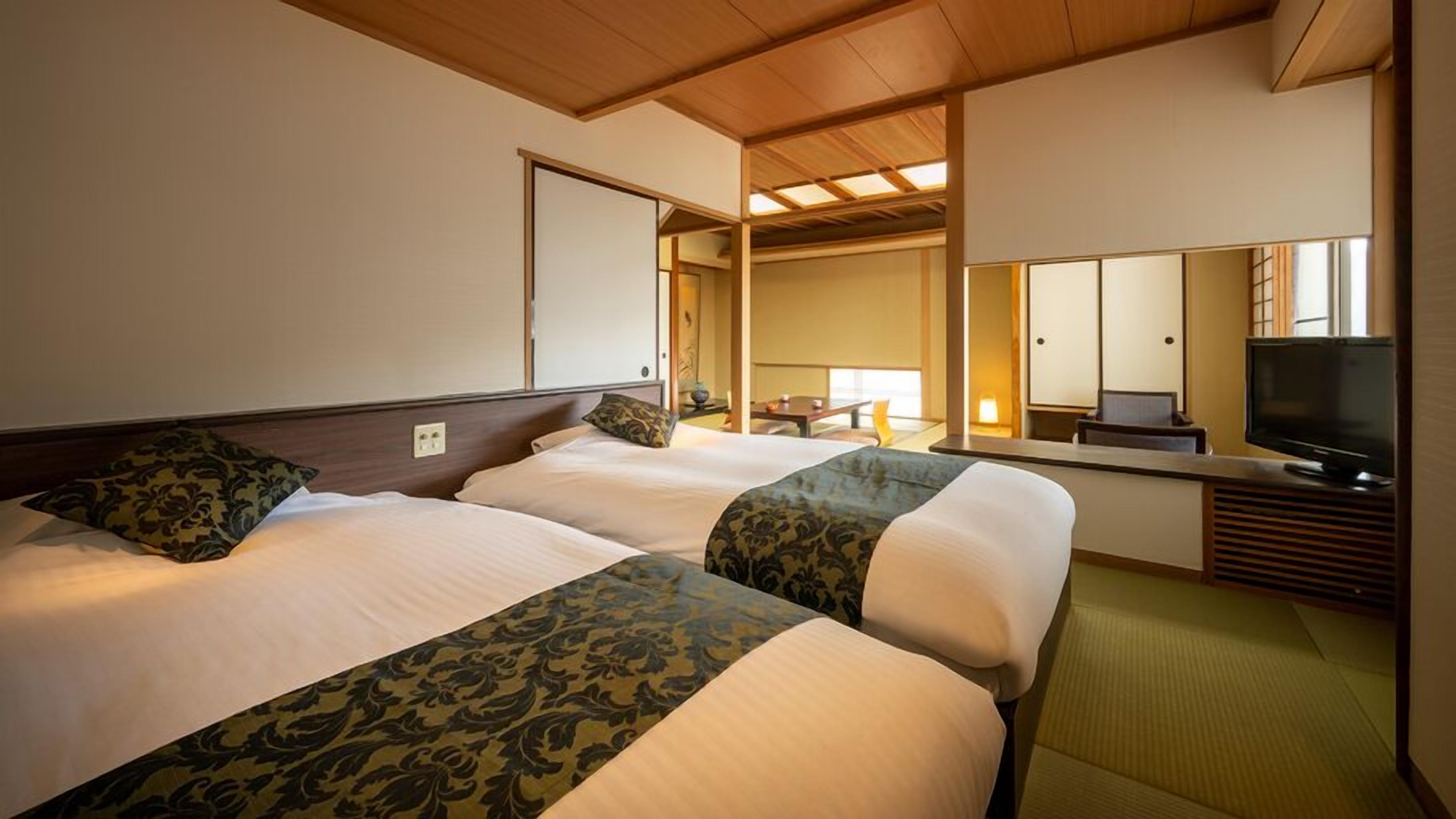 Una habitación de hotel con dos camas, una televisión y un espejo.
