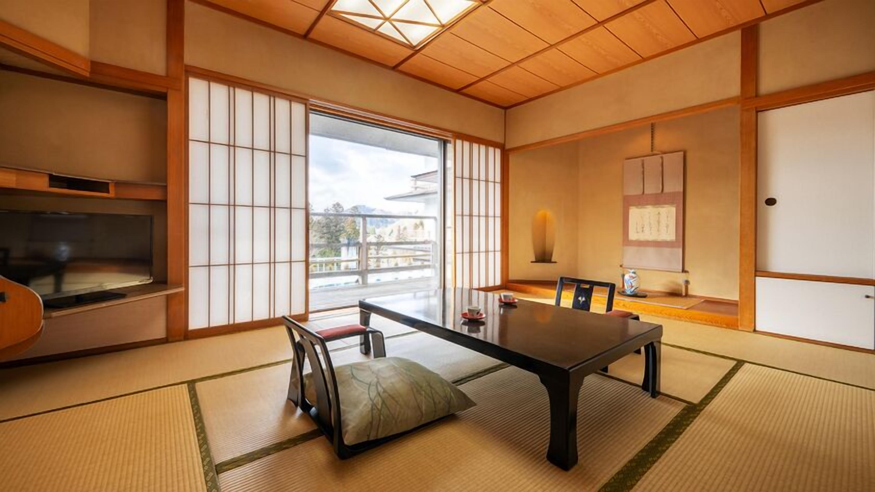 Een traditionele Japanse kamer met tatami vloerbedekking, een lage tafel en schuifdeuren.