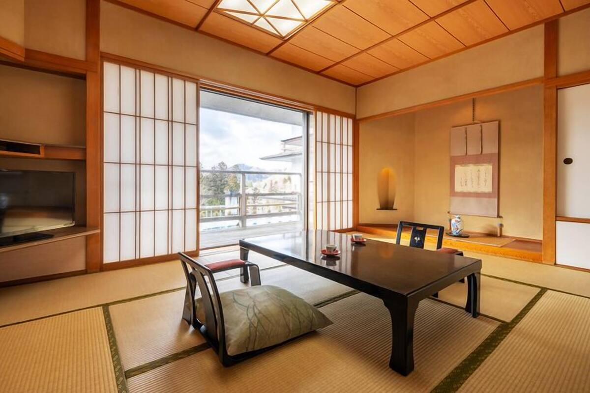 Une pièce de style japonais traditionnel, avec un sol recouvert de tatamis, une table basse et des portes coulissantes.