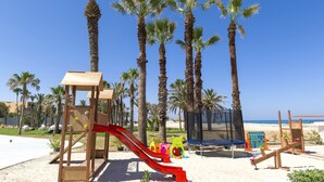 A playground with a slide, climbing structures, and a trampoline. - Hotel Tour Khalef (Sousse)
