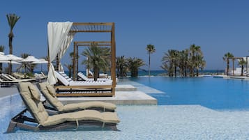 Una piscina techada, 2 piscinas al aire libre, sombrillas
