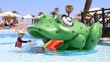 A child playing in a pool with a large frog water slide.
