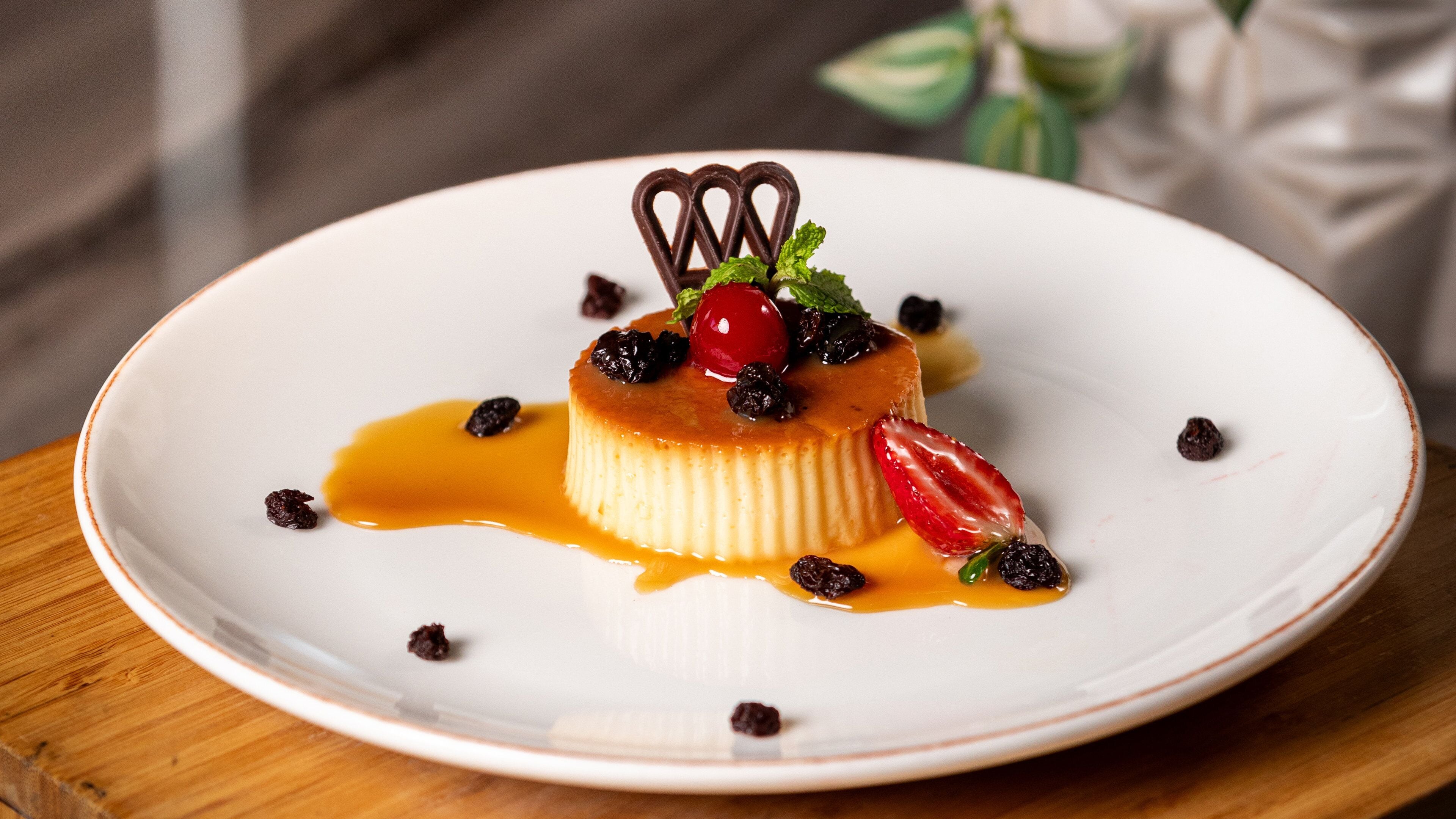 A dessert on a white plate with caramel sauce and berries.