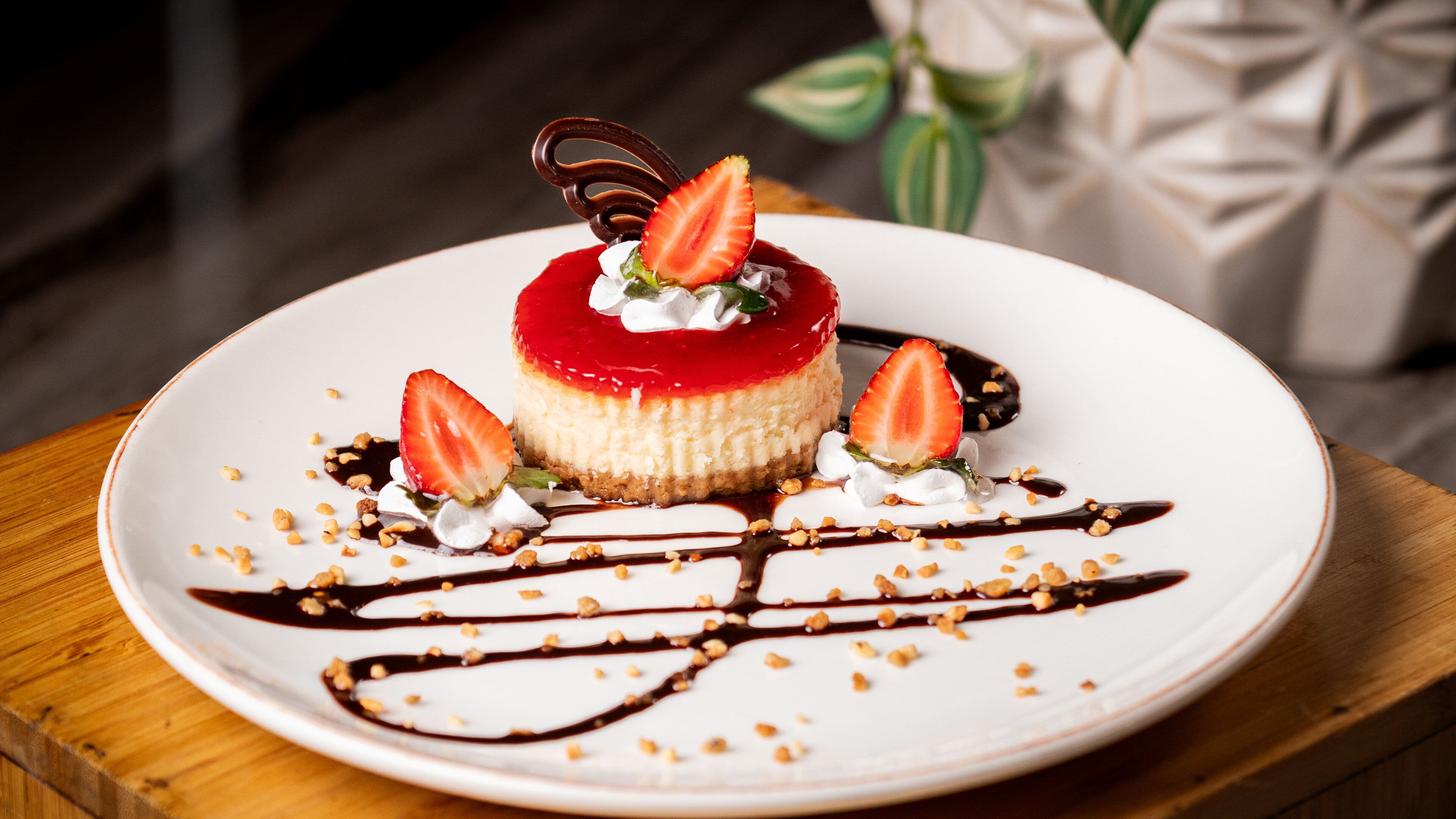 A dessert on a white plate with chocolate sauce and strawberries.