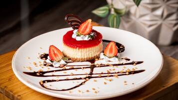 A dessert on a white plate with chocolate sauce and strawberries.