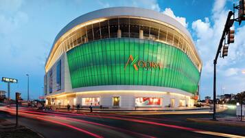 A large, modern stadium with a green facade and the name "GORA Mall" on the side.