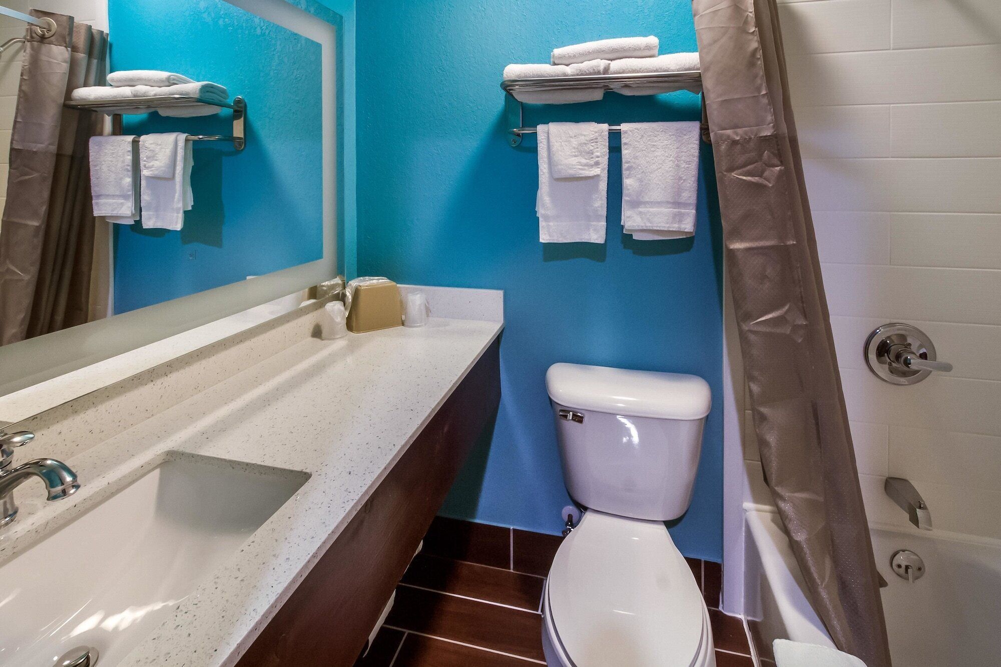 A bathroom with a sink, toilet, and towel rack.