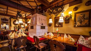 A restaurant with wooden furniture, hanging lamps, and a mural on the wall. - Hotel & Restaurant Hackteufel (Heidelberg)