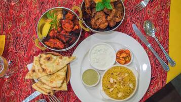 Un tavolo con diversi piatti, tra cui pane piatto, riso e una ciotola di curry.