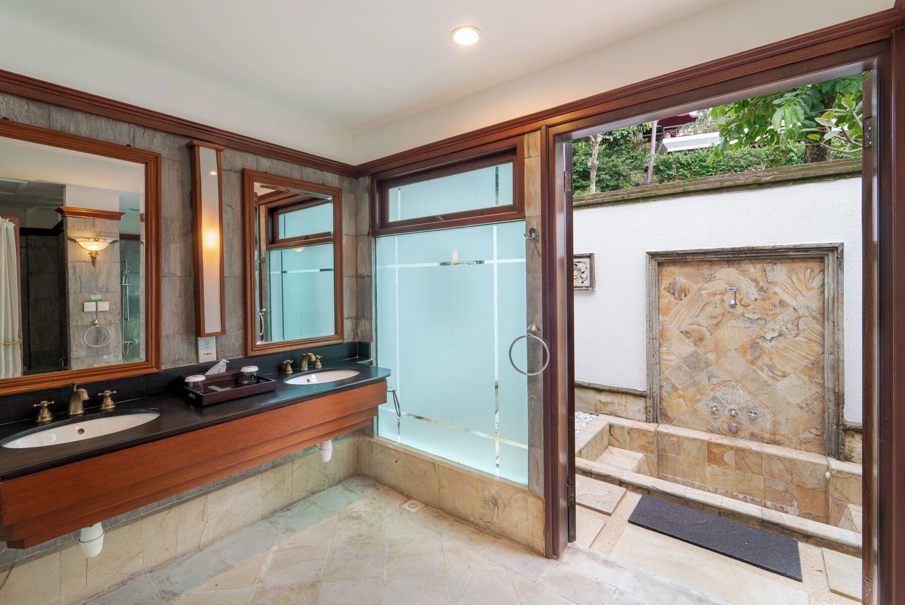 Un baño con dos lavamanos, un espejo grande y una cabina de ducha de vidrio.