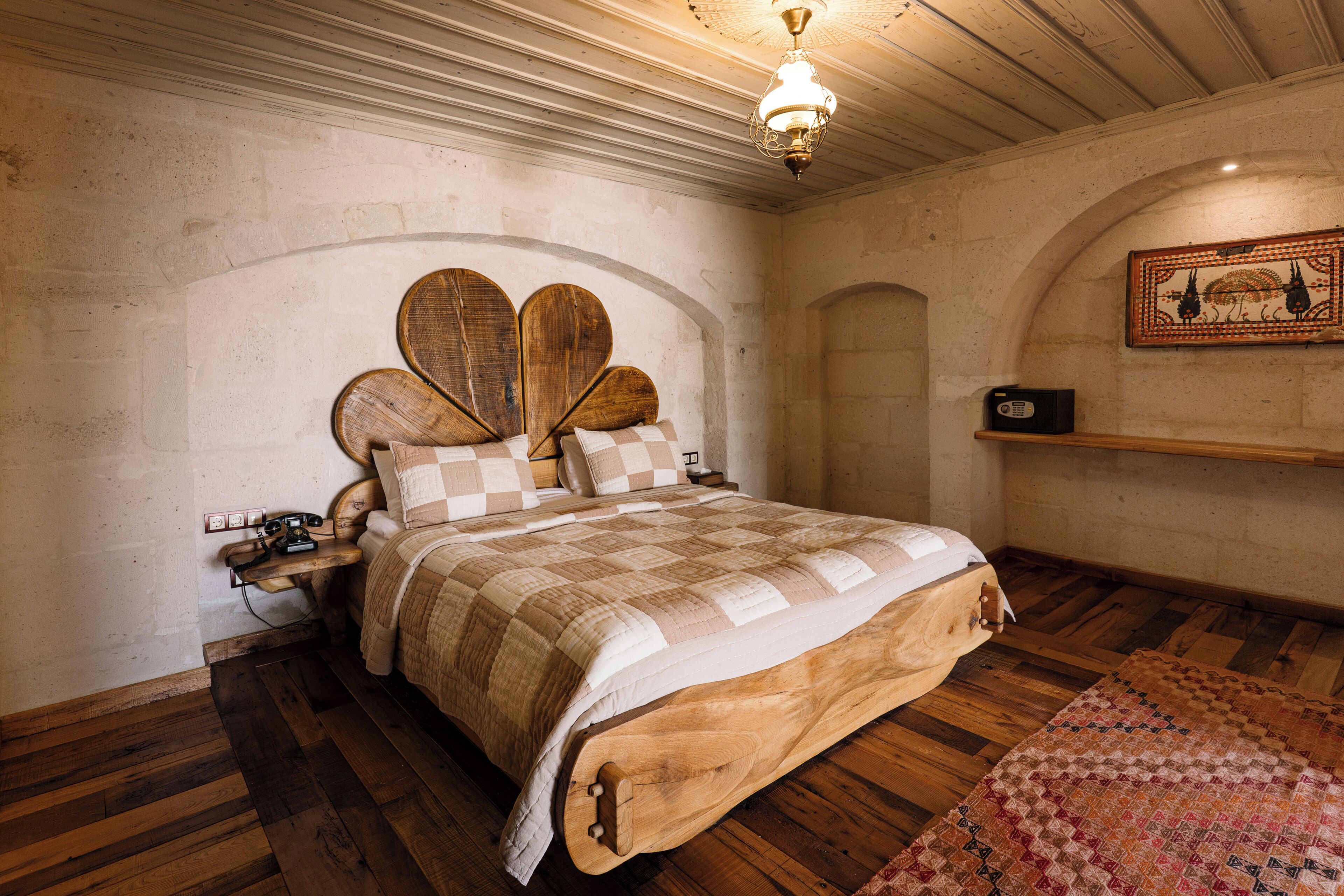 A bedroom with a wooden bed, a nightstand, a radio, and a decorative wall piece.