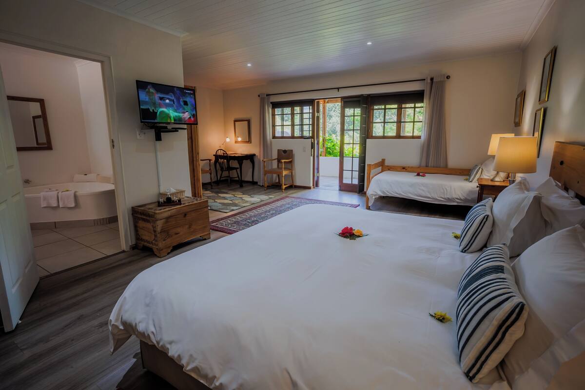 Una habitación de hotel con dos camas, televisión, escritorio y baño.