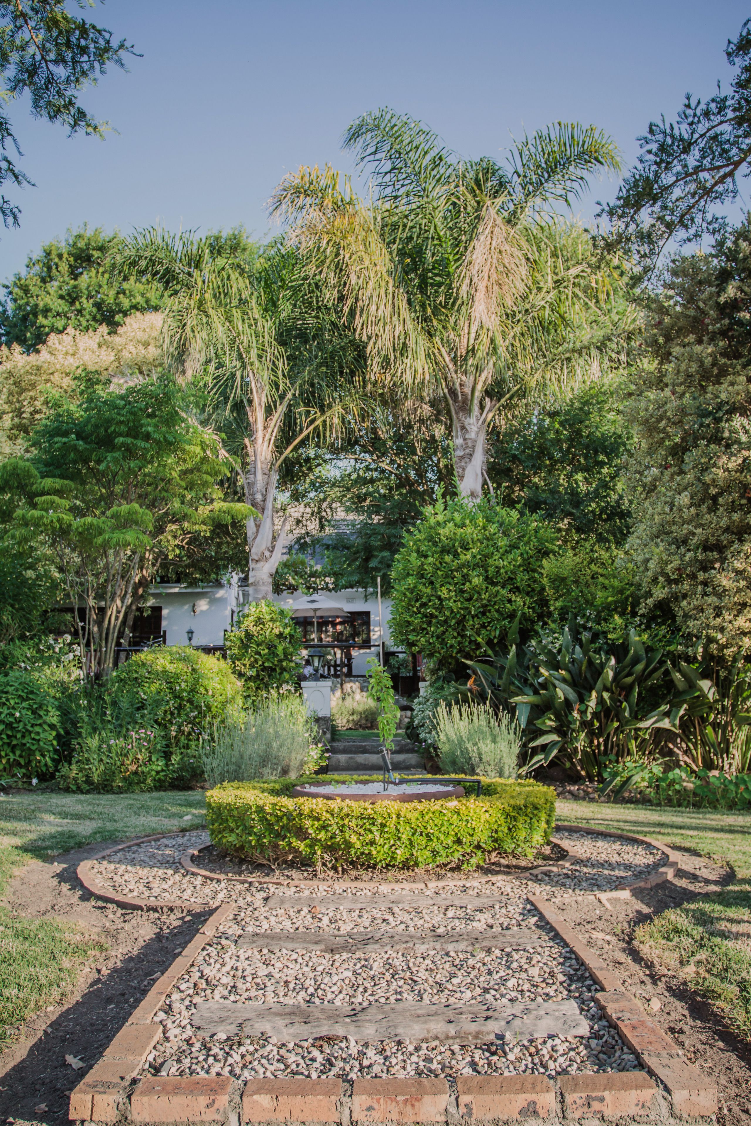 Un jardín con un sendero que lleva a un edificio con escaleras.