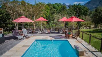 Piscine extérieure, parasols de plage, chaises longues