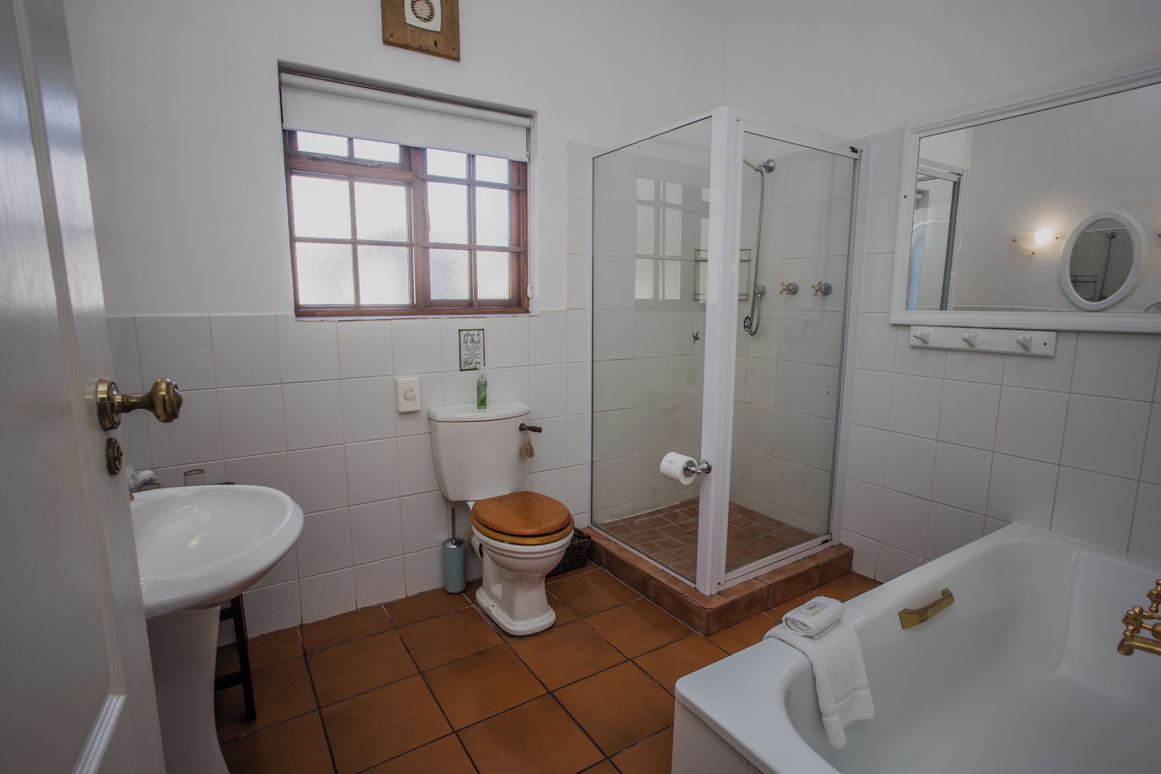 A bathroom with a toilet, sink, shower, and bathtub.
