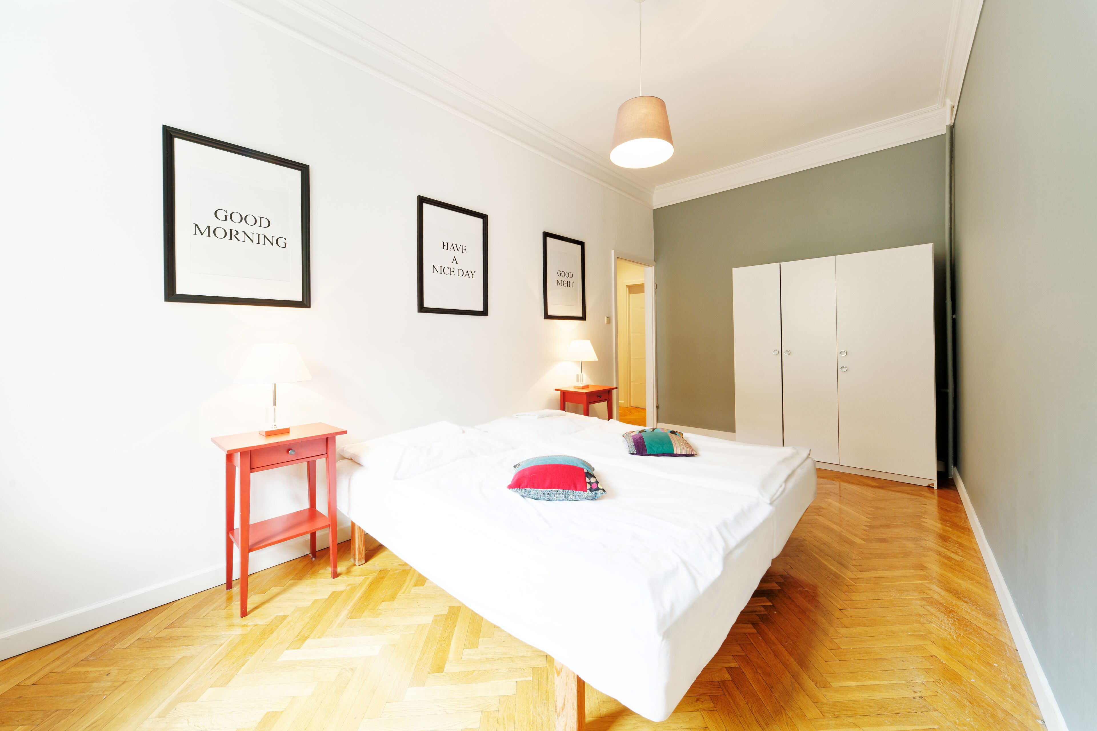 Ein Schlafzimmer mit einem Bett, einem Nachttisch, einer Lampe und einem Kleiderschrank.
