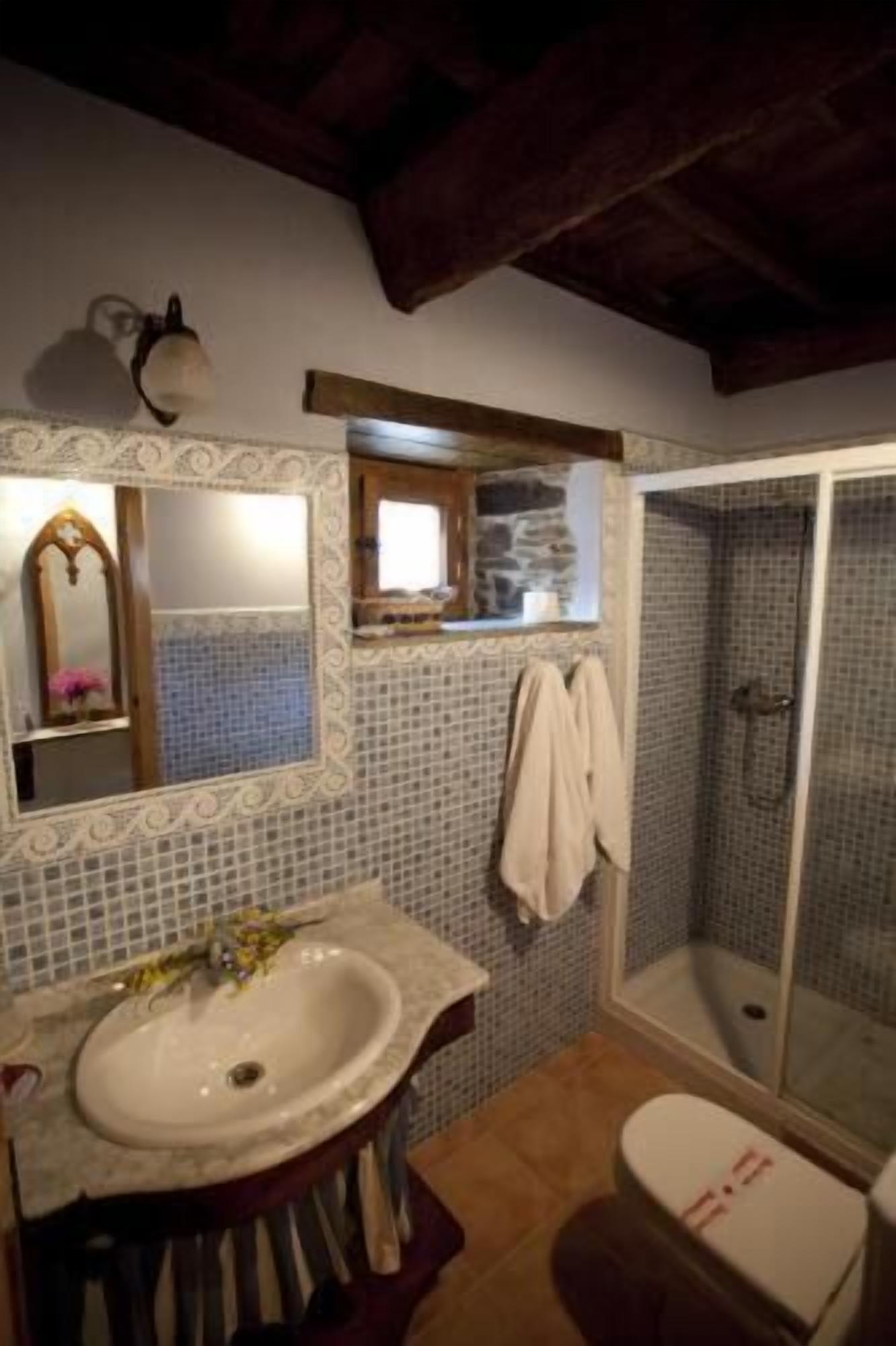 A bathroom with a sink, mirror, and shower.