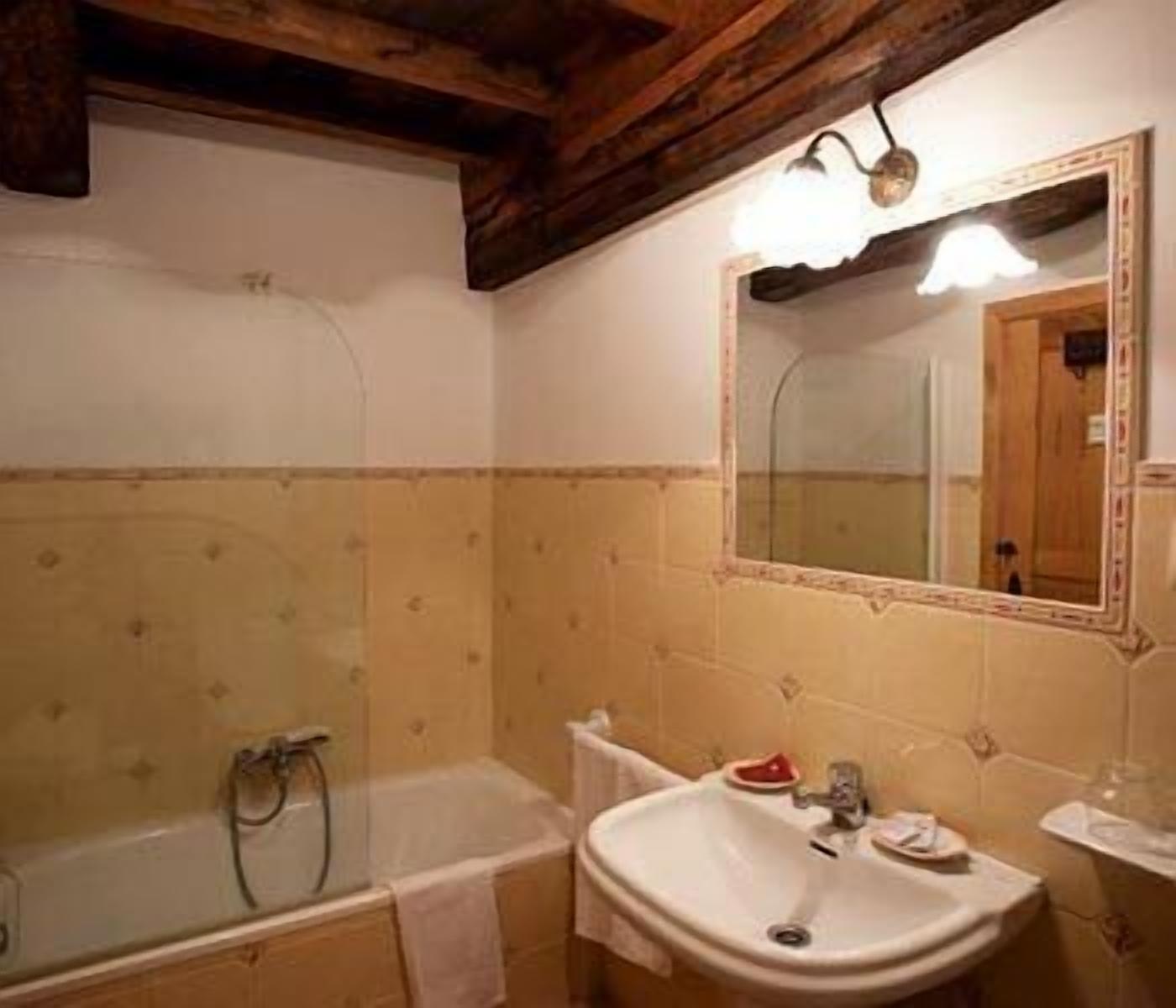 Een badkamer met een bad, wastafel en spiegel.