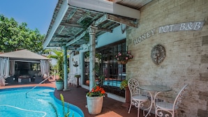 A pool area with a sign reading "HONEY POT B&B". - HoneyPot Guesthouse (Umhlanga)