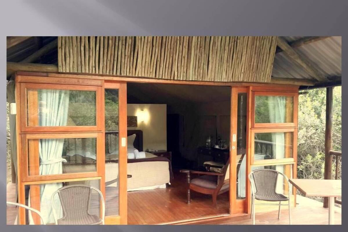 A room with a bed, a desk, and a chair. There is a window and a door.