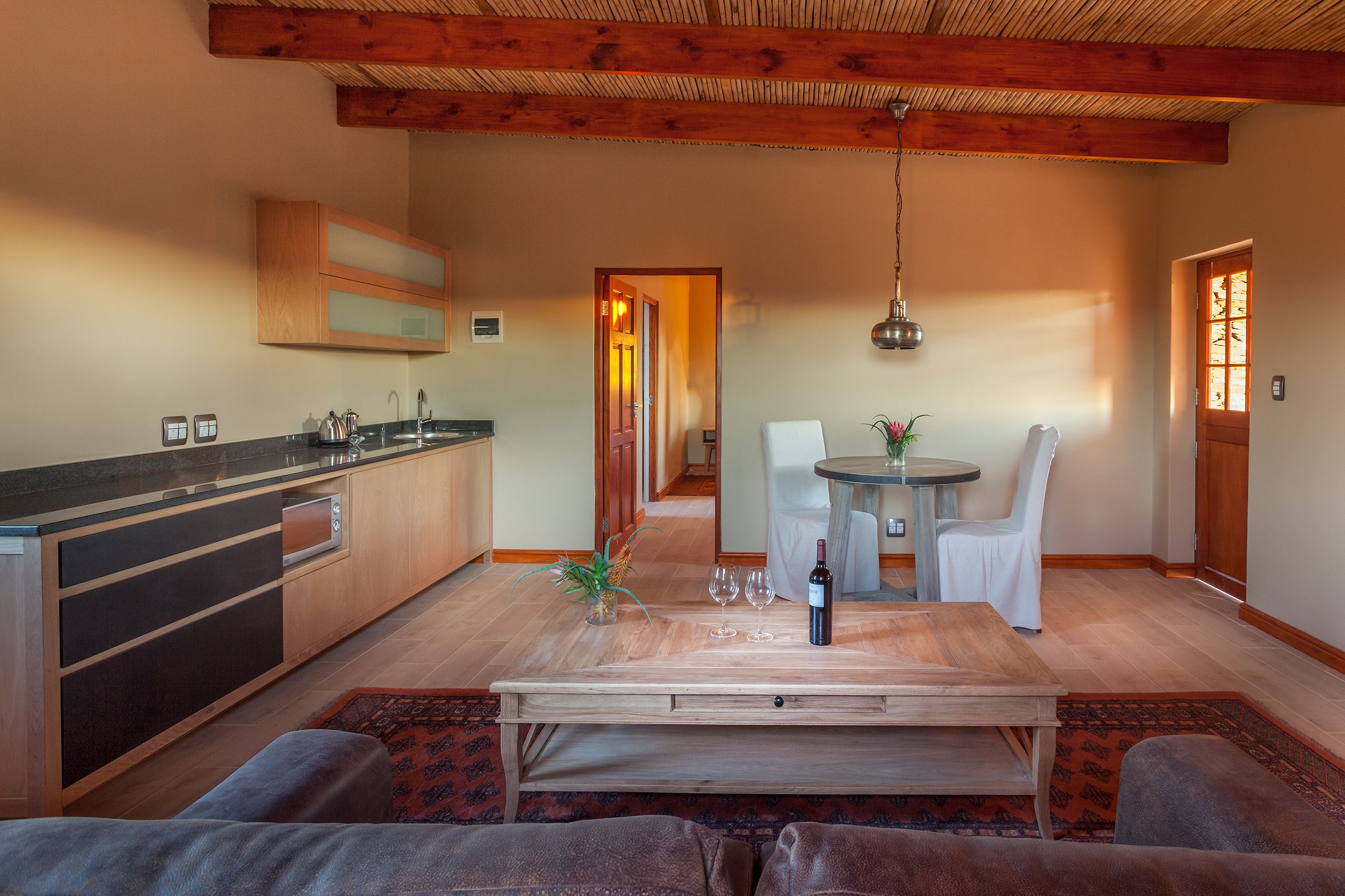 A modern kitchen with wooden cabinets and a dining area with a table and chairs.