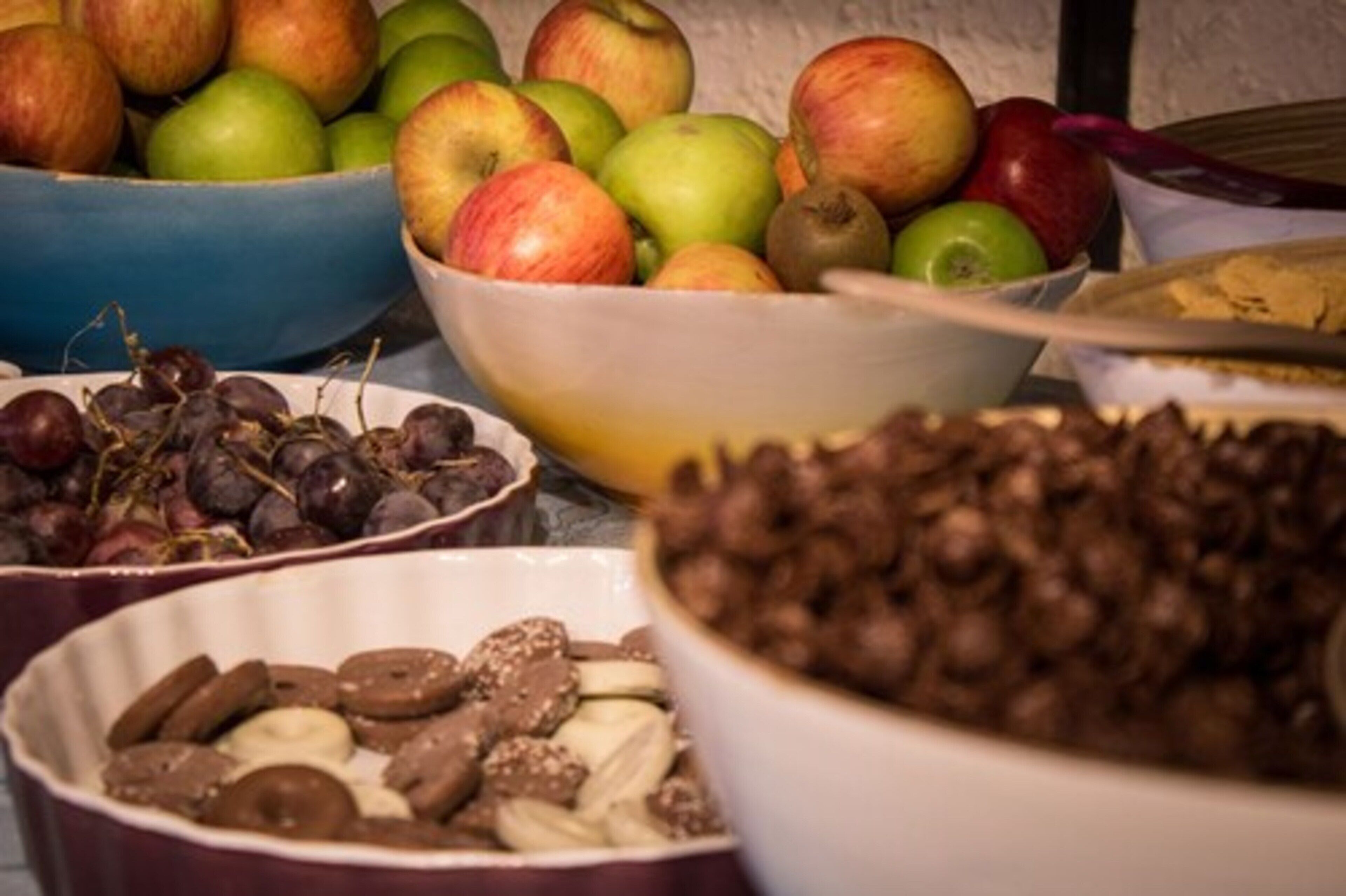 Una mesa con recipientes que contienen diversas frutas y frutos secos.
