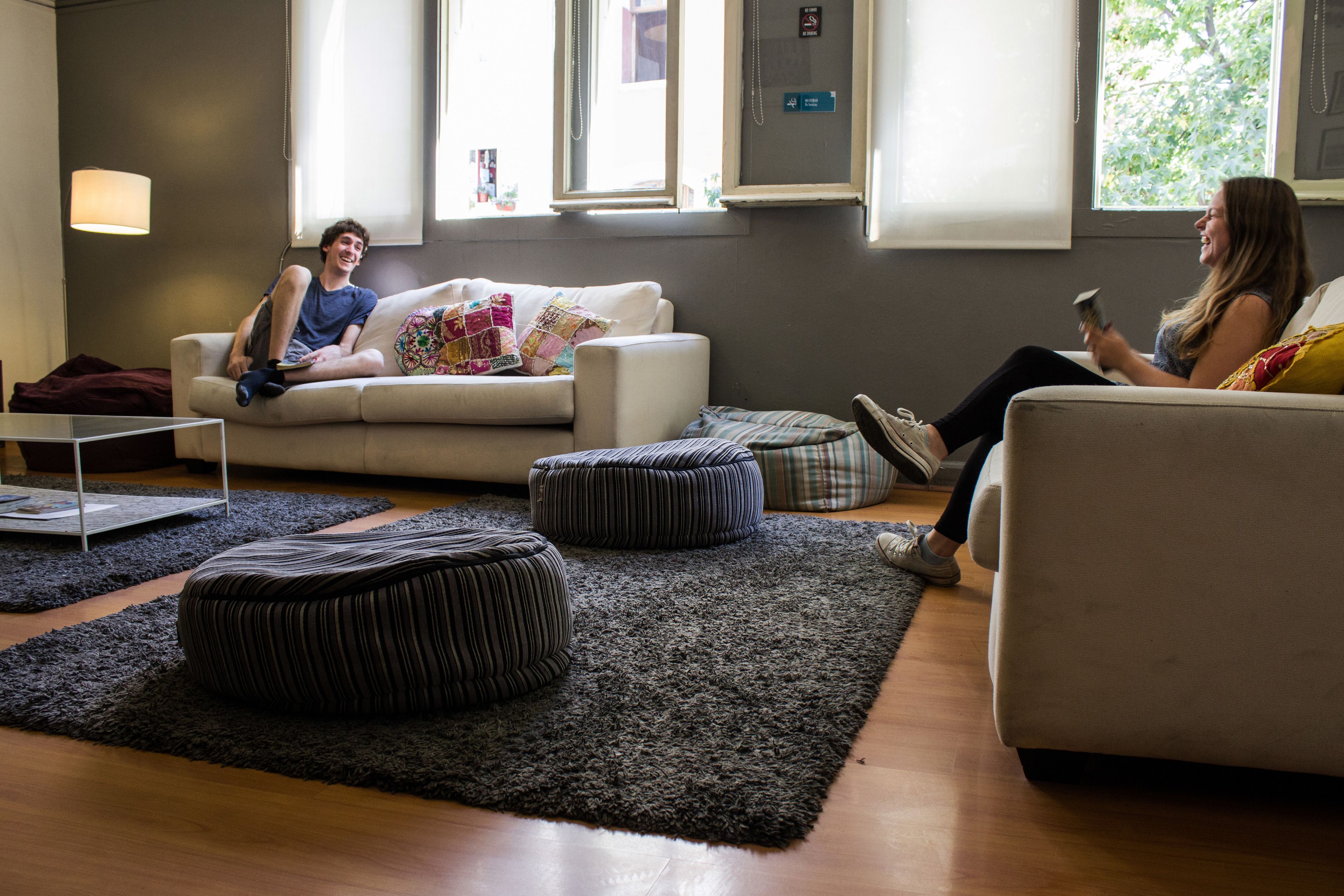 A modern living room with a sofa, ottomans, and a coffee table.