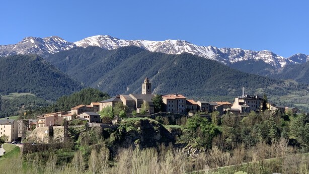 A mountain village with traditional stone buildings and a prominent church tower. - Fonda Biayna (Bellver de Cerdanya)