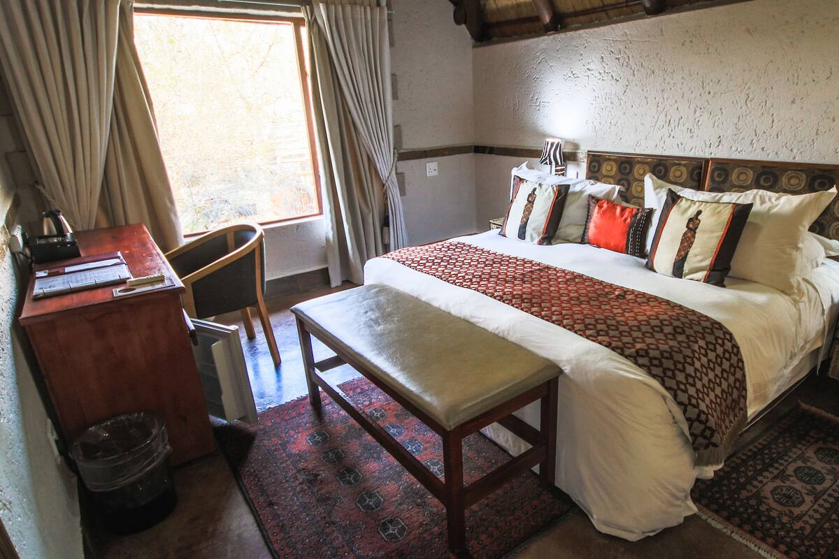 Ein Schlafzimmer mit einem großen Bett, einem Schreibtisch und einem Sessel.