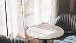 A modern room with a round table, two chairs, and a floor lamp. - VICI Hotels Linköping (Linkoping)