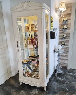 A white, ornate cabinet with glass doors displaying various items. - Hotel Vila Santa (Lima)