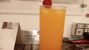 A tall glass with a gradient drink, a menu board, and a hotel sign.