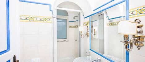 Een badkamer met een witte wastafel, een spiegel en blauwe betegelde wanden.