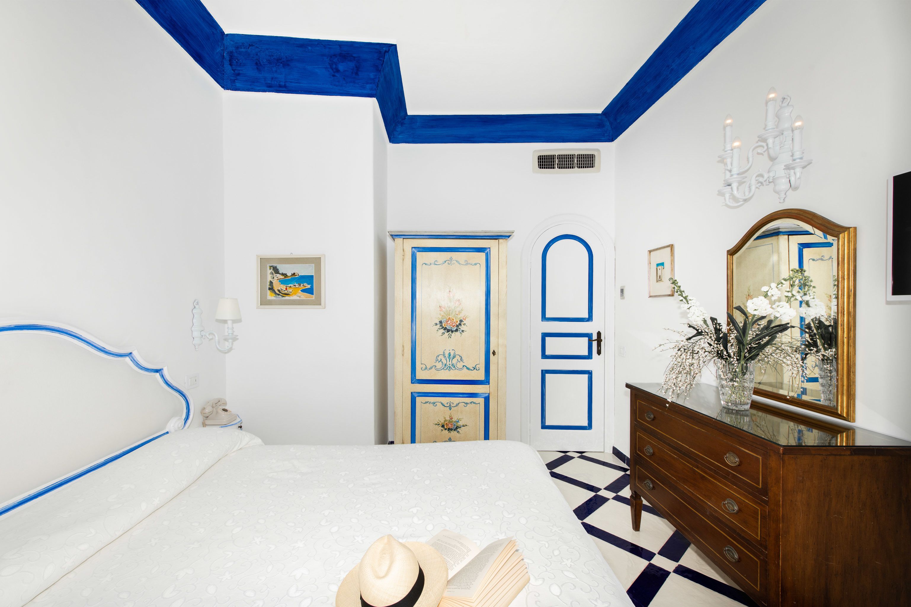 A bedroom with a bed, dresser, and a door with floral decorations.