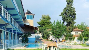 A hotel with a swimming pool, outdoor seating, and a large tree. - Goreme Sakura  (Denizli)