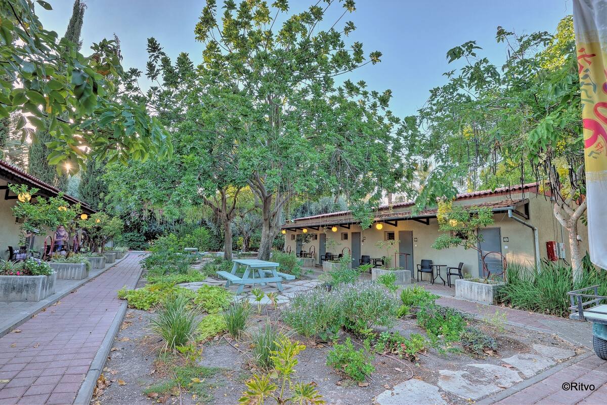 A courtyard with outdoor seating, a fountain, and a building with a tiled roof.