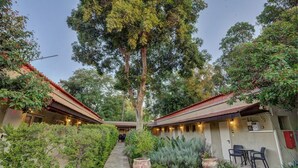 A courtyard with two-story buildings, a central pathway, and outdoor seating. - Kibbutz Ashdot Yaacov Ichud Country Lodging (Emek HaYarden)