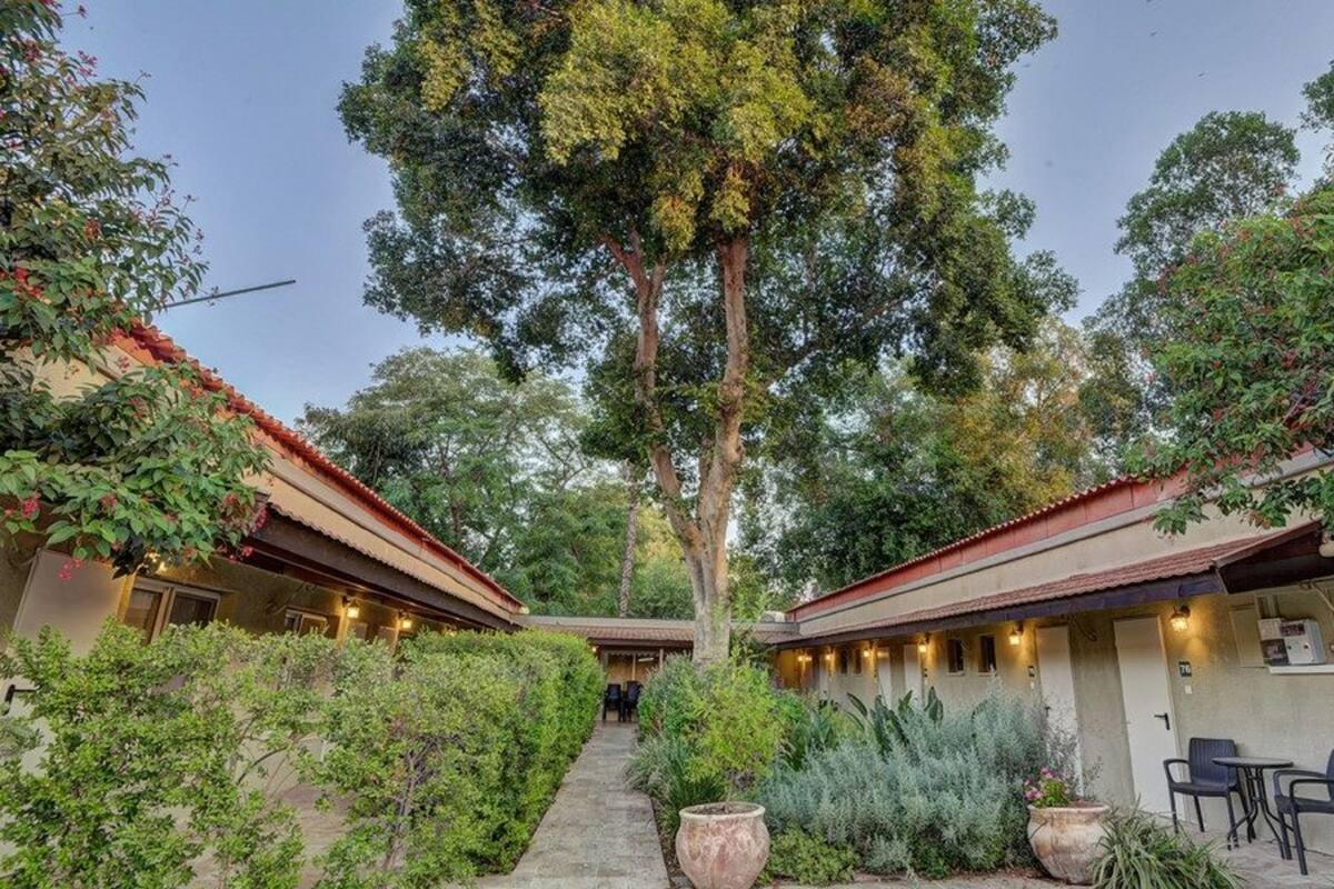 A courtyard with two-story buildings, a central pathway, and outdoor seating.