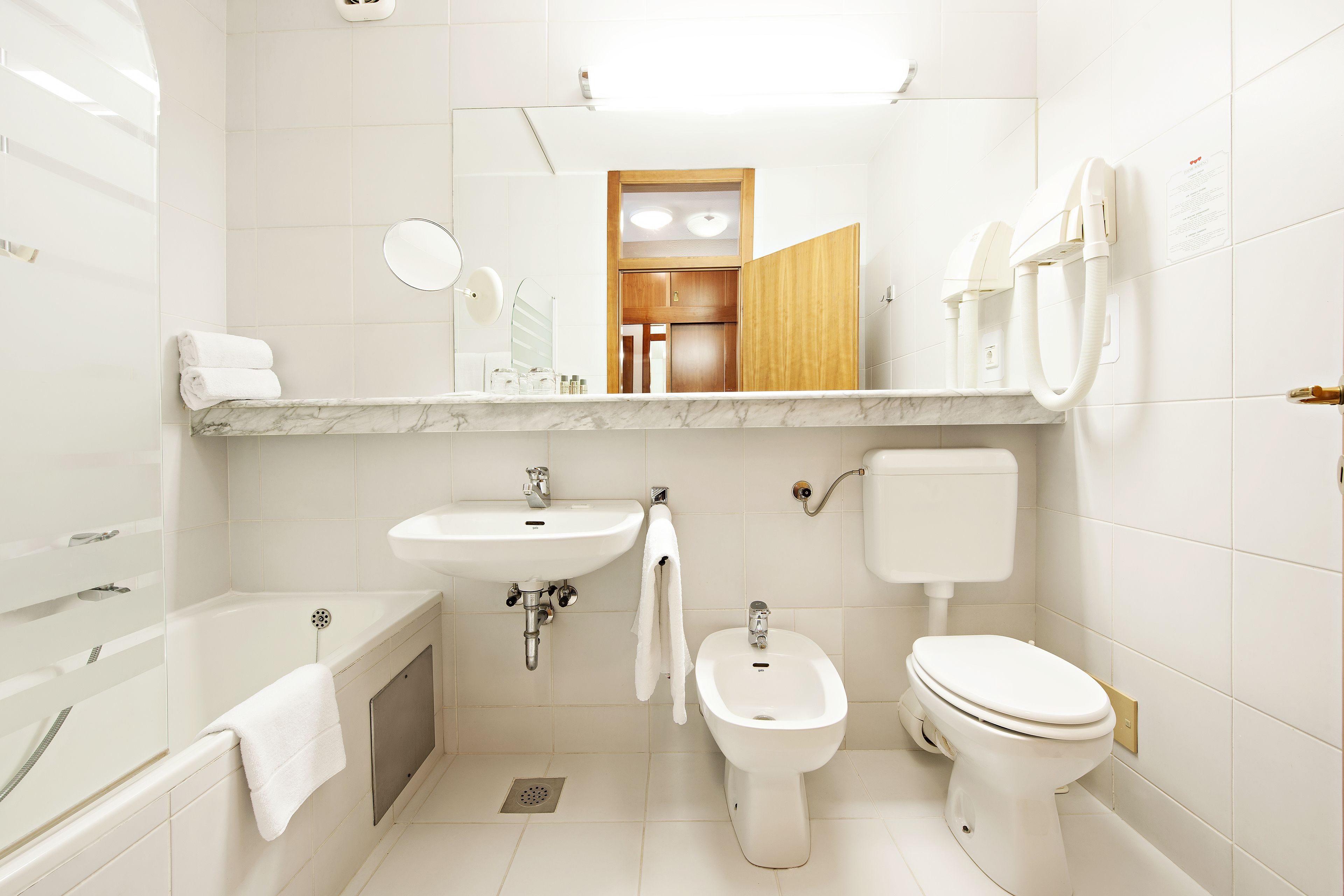 Un baño moderno con bañera, lavabo, bidé e inodoro.