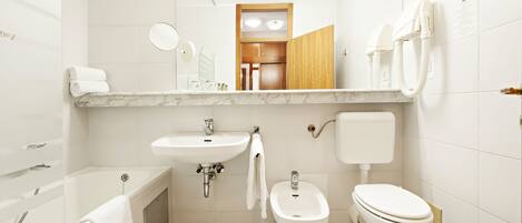 Un baño moderno con bañera, lavabo, bidé e inodoro.
