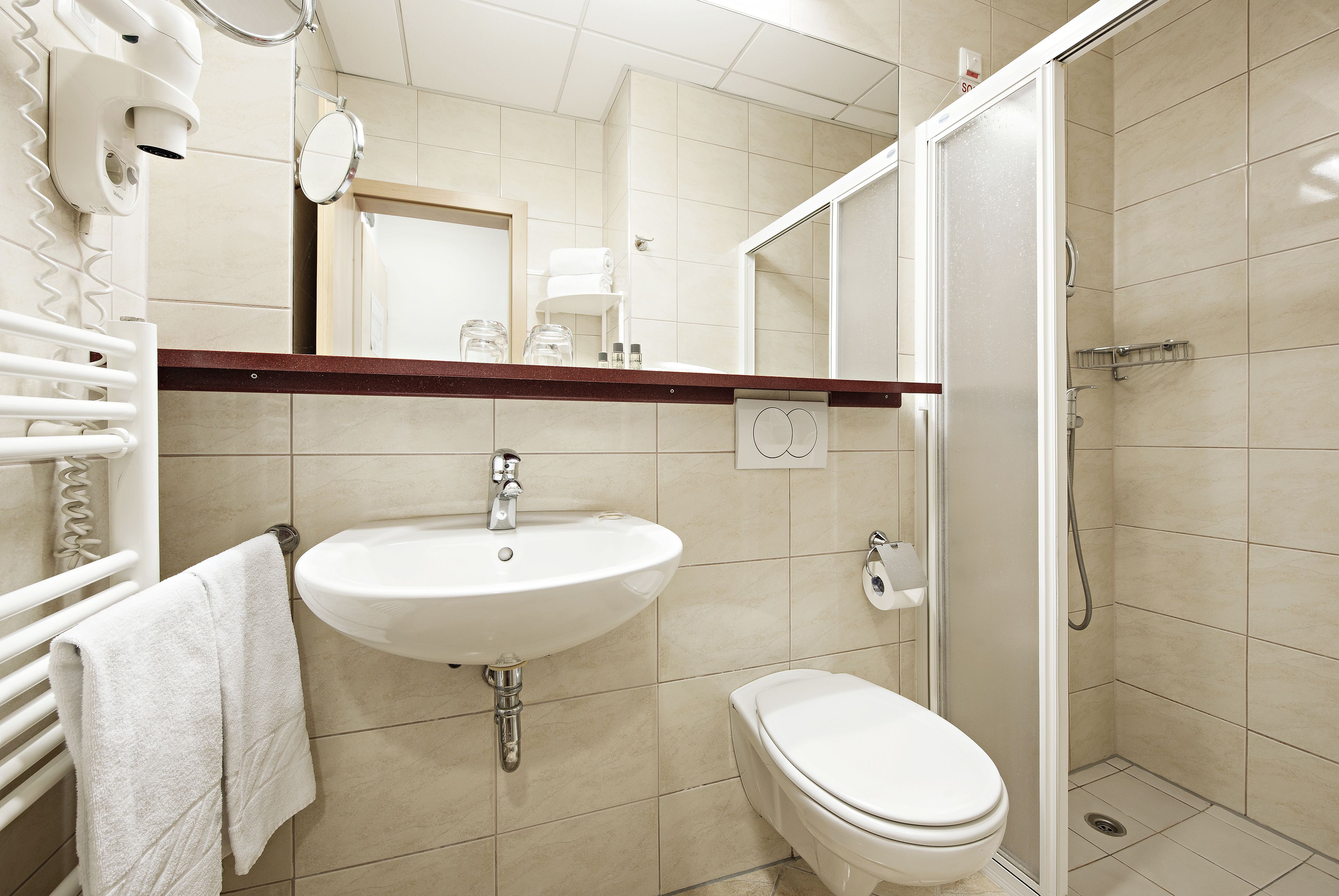 A bathroom with a sink, toilet, and shower.