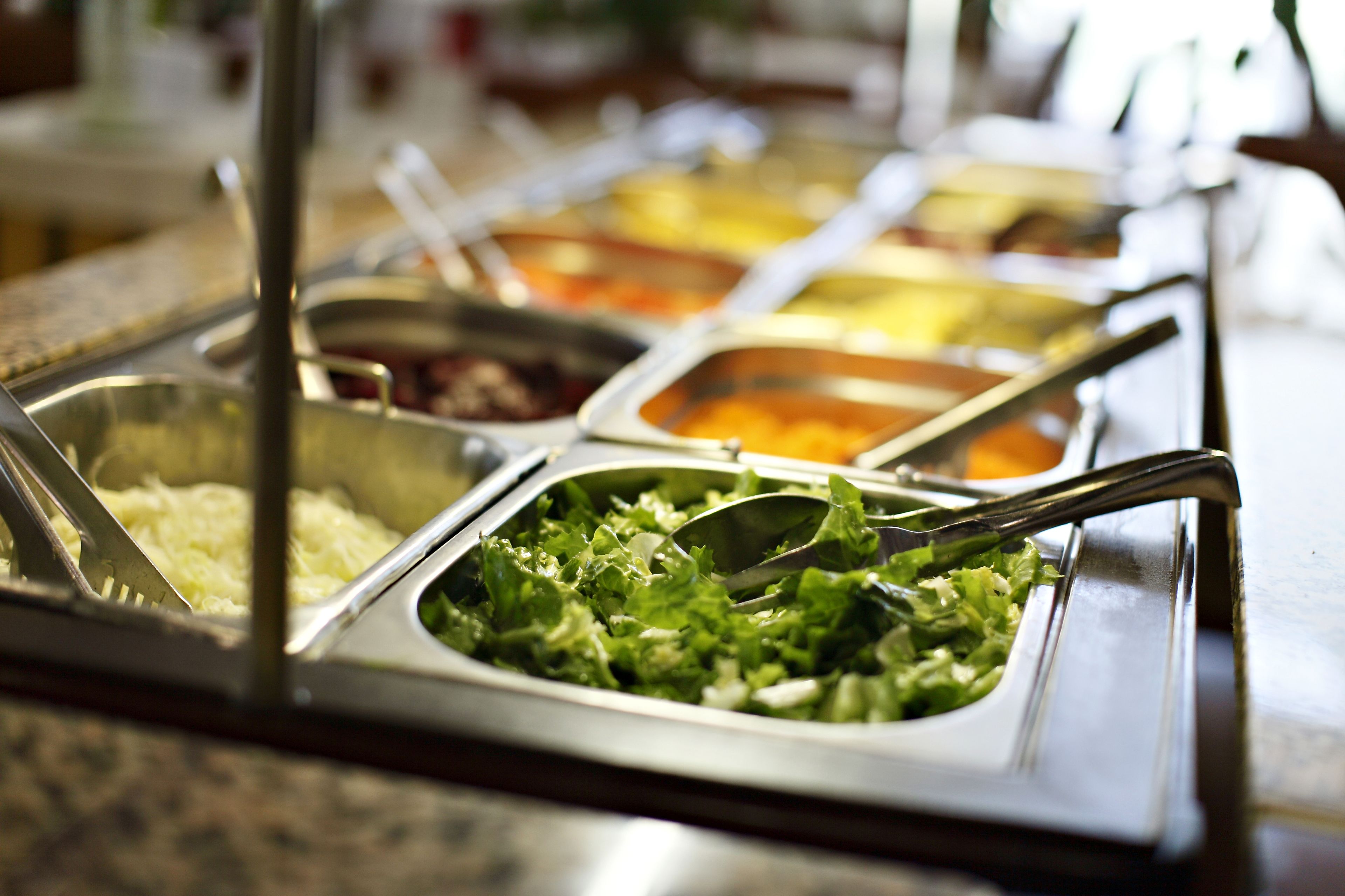 Ein Buffet mit verschiedenen Speisen, darunter Salate, Pasta und weitere Gerichte.
